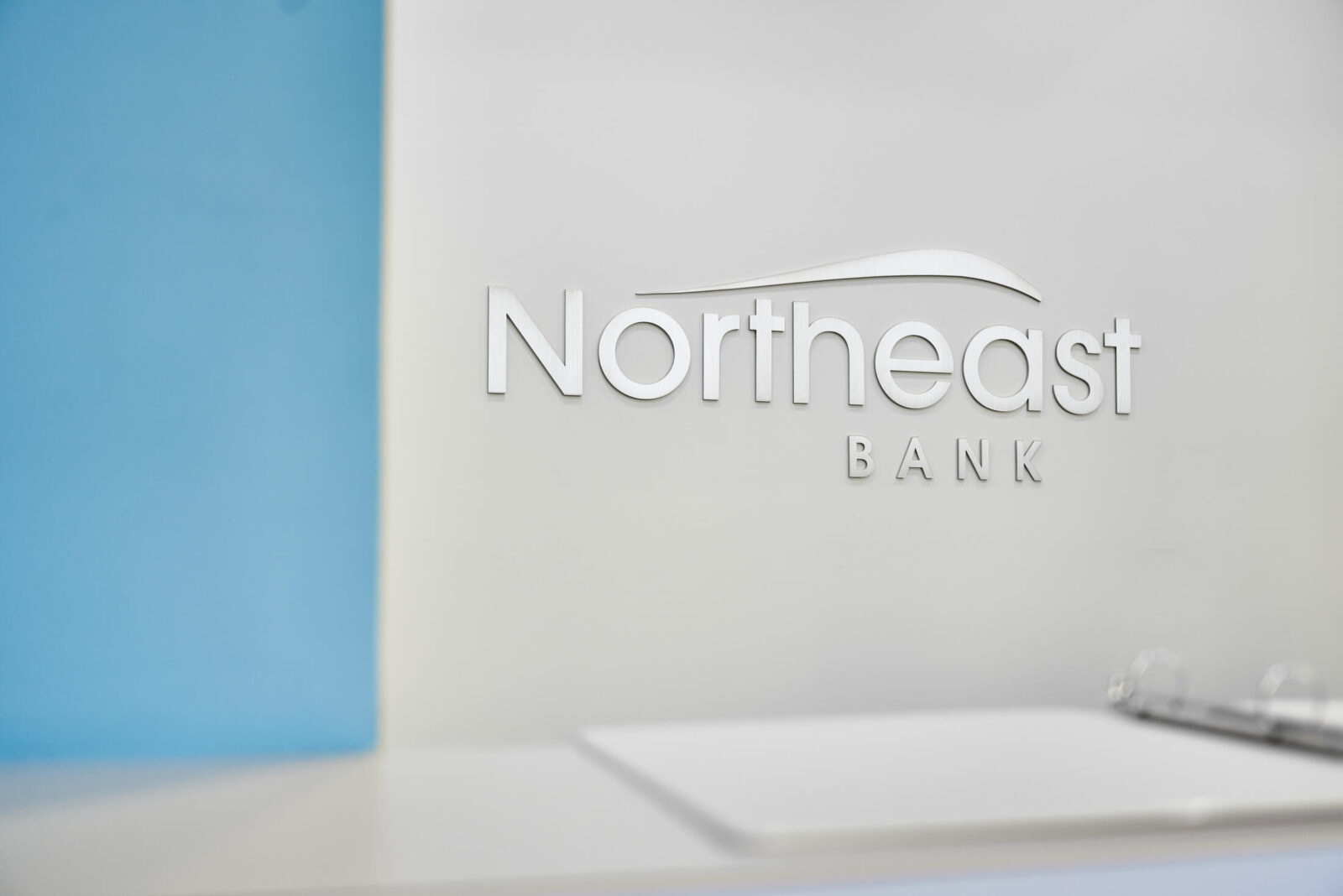 Northeast Bank logo mark on white wall