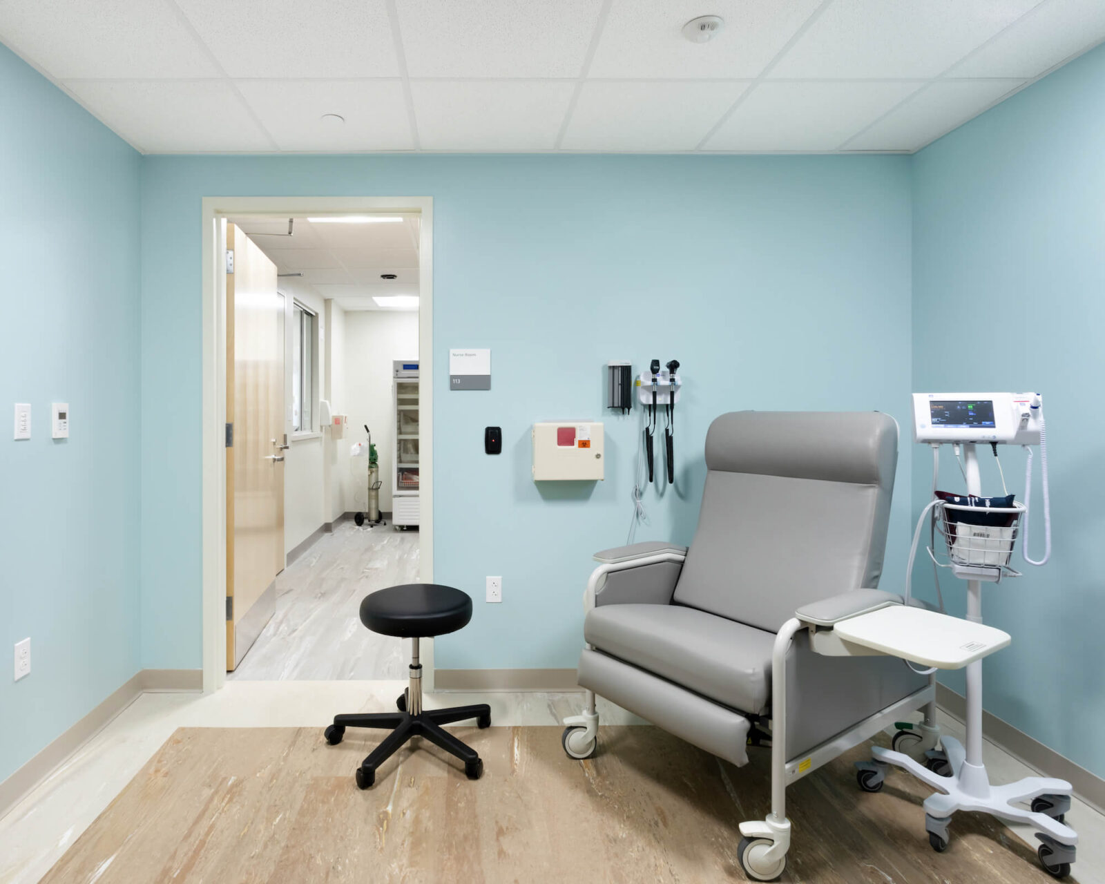 A medical examination office with a large exam chair and medical equipment