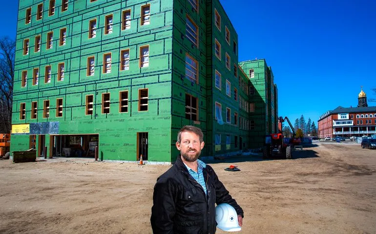 Tim Hebert standing in front of a large building under construction