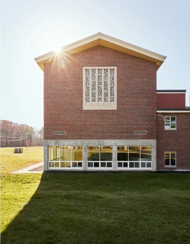Exterior of Merci Woods with big windows and sunset in the background